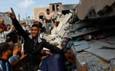 イスラム組織ハマスの攻撃を受け、イスラエルが報復として攻撃したパレスチナ自治区ガザで崩壊した建物と救助活動にあたるパレスチナ人たち=ロイター