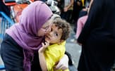 20日、パレスチナの家を逃れ、国連の運営する施設に避難した女性と子供=ロイター